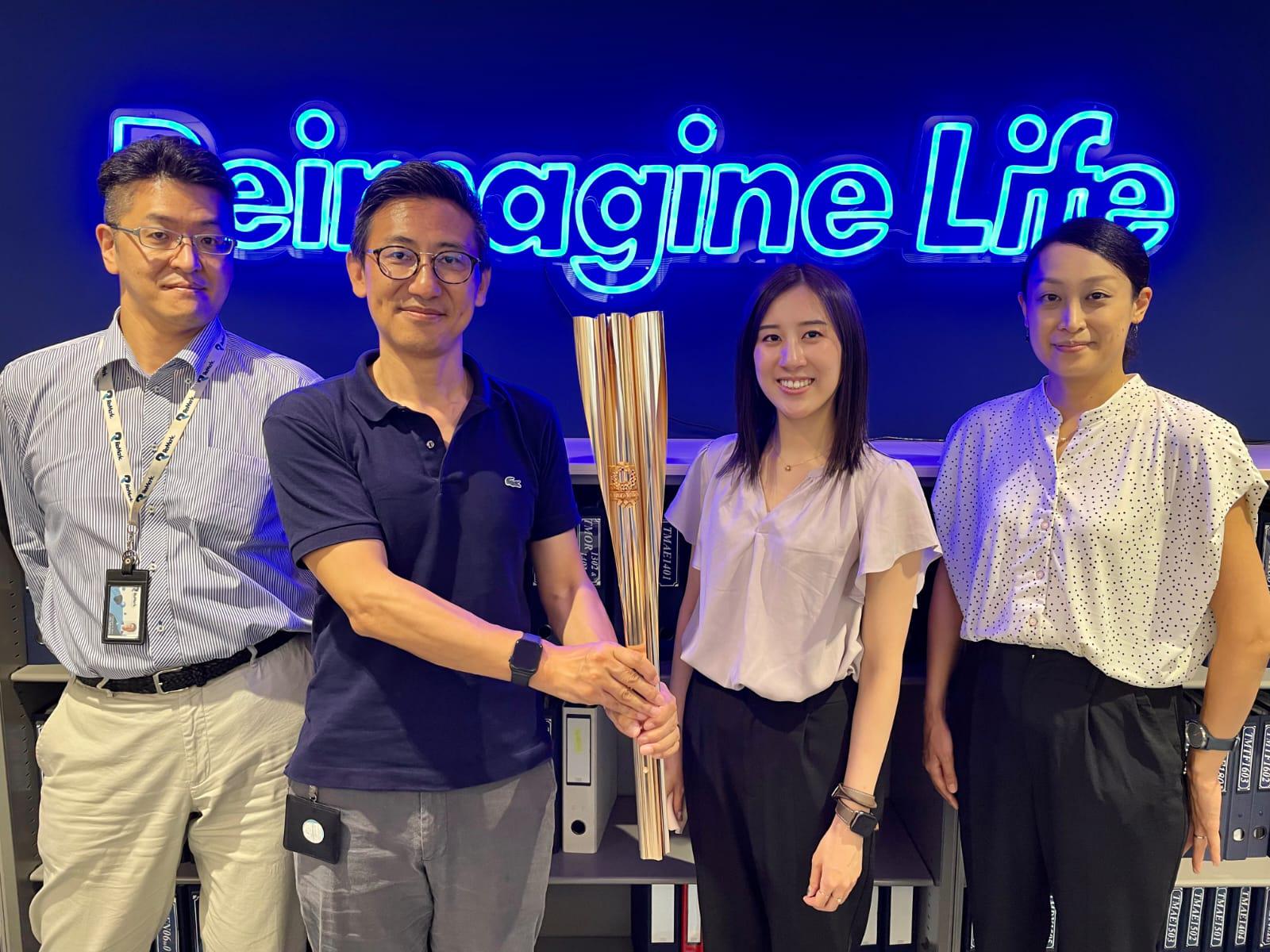 Ayaka and her colleagues welcome the torch at the Tokyo office